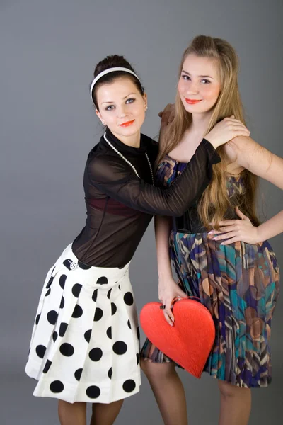 Deux filles heureuses tenant coeur rouge — Photo