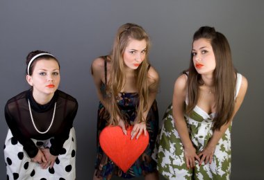 Kırmızı kalp tutan üç mutlu kız