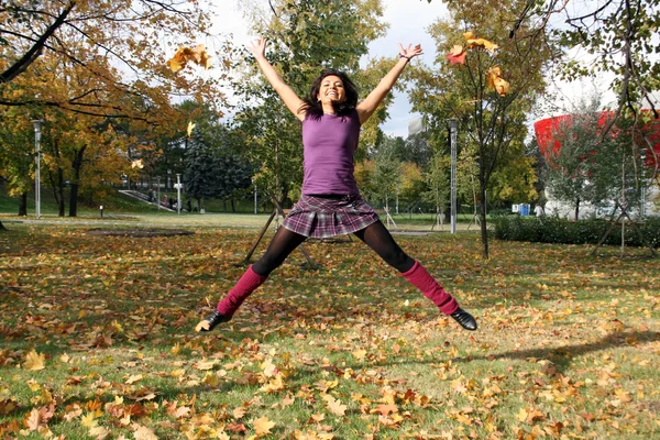 Mulher alegre pulando no parque de outono — Fotografia de Stock