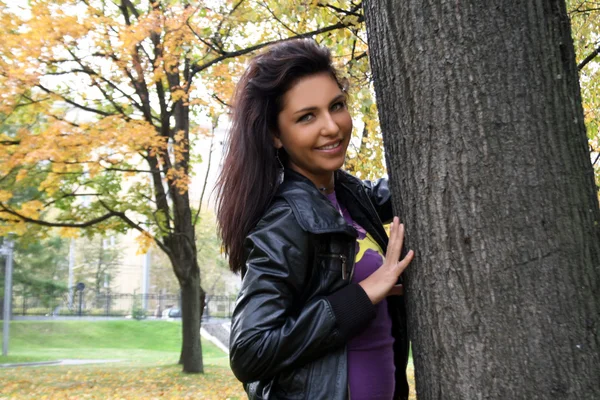 Красивая молодая женщина стоит рядом с деревом — стоковое фото