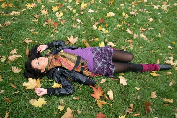 Smiling woman lying on a carpet — Stock Photo, Image