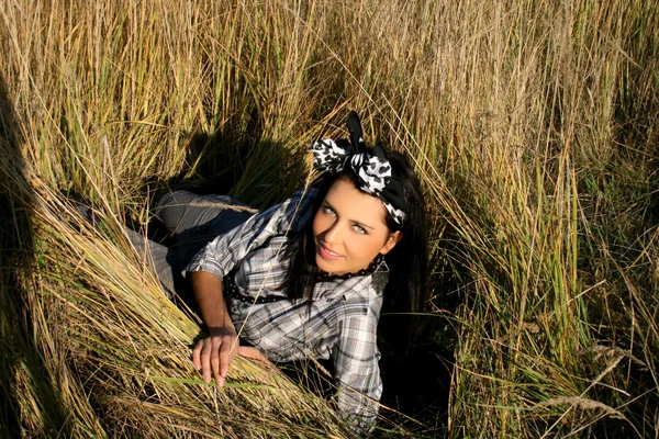 Piękna młoda kobieta, leżąc na pole — Zdjęcie stockowe