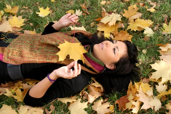 Mujer joven y bonita acostada en una alfombra — Foto de Stock