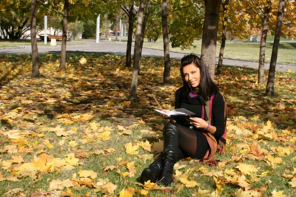 Улыбающаяся женщина читает книгу в — стоковое фото
