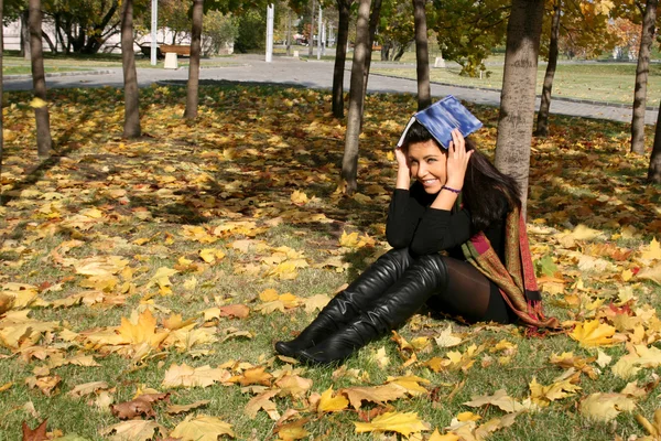 Αστείο κορίτσι με ένα ένα βιβλίο στο πάρκο φθινόπωρο — Φωτογραφία Αρχείου