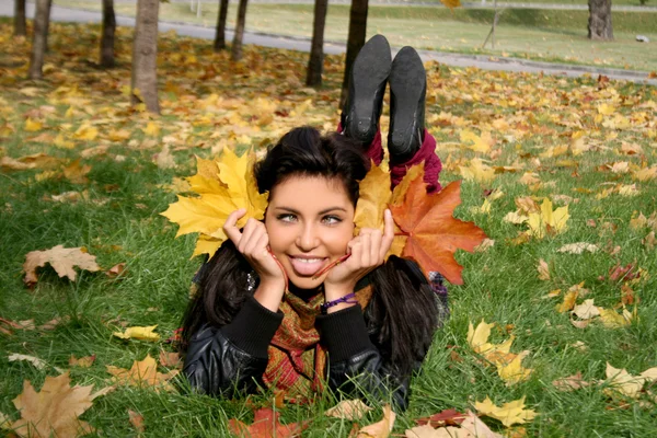 Vicces nő feküdt a szőnyegen a levelek — Stock Fotó