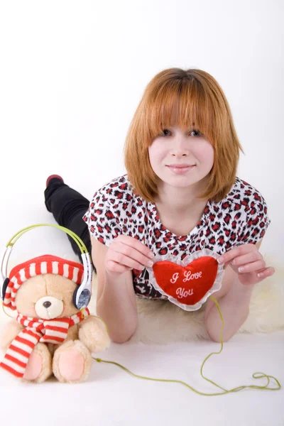 Meisje en teddybeer met koptelefoon — Stockfoto