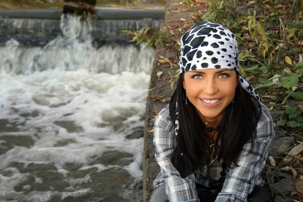 Kvinnliga pirat sitter nära vattenfallet坐在瀑布附近的女海盗 Stockbild