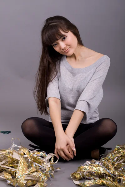 Girl sitting among tinsel — Stock Photo, Image