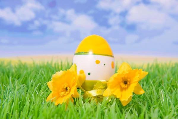 Huevo de Pascua de plástico sobre hierba con flores —  Fotos de Stock