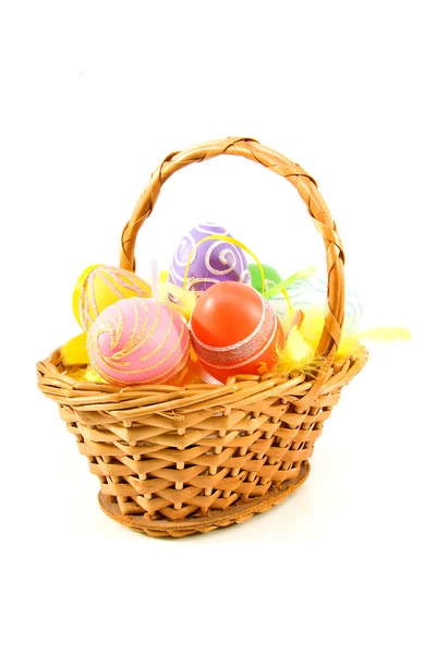 Cane basket with colorful easter eggs — Stock Photo, Image