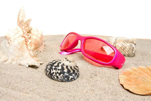 Roze zonnebril op het strand — Stockfoto