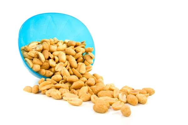 Соленый арахис, падающий из синей чаши — стоковое фото