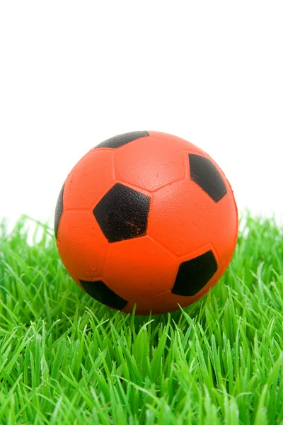Bola de futebol laranja na grama — Fotografia de Stock