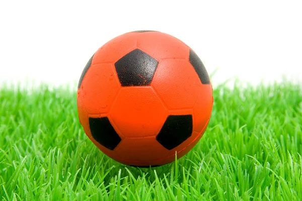 Çimenlerin üzerinde turuncu futbol topu — Stok fotoğraf
