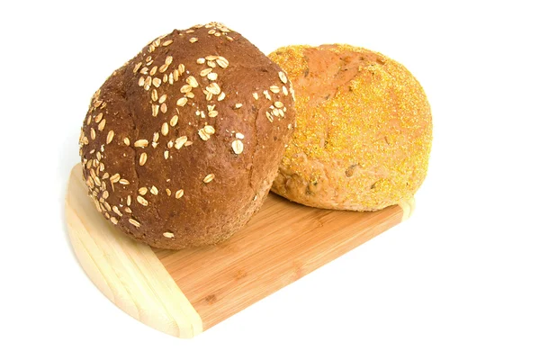 Dois pães saudáveis em tábua de madeira — Fotografia de Stock
