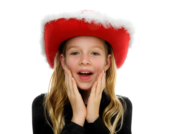 Girl with christmas hat looks surprised — Stock Photo, Image