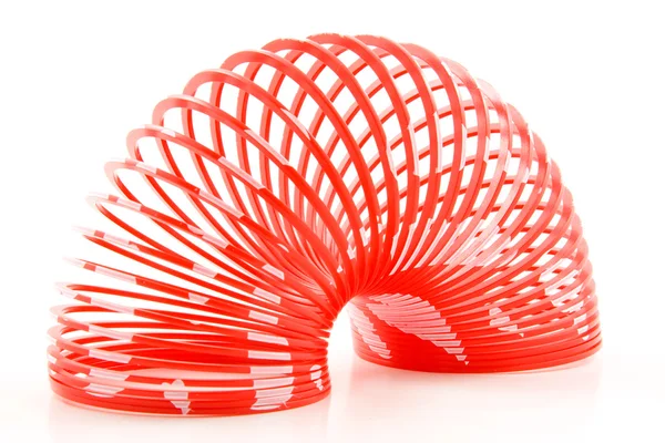 Brinquedo de mola de plástico vermelho isolado no fundo branco — Fotografia de Stock