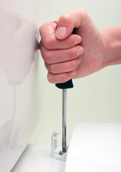 Vrouwelijke hand schroevendraaier vaststelling toilet — Stockfoto