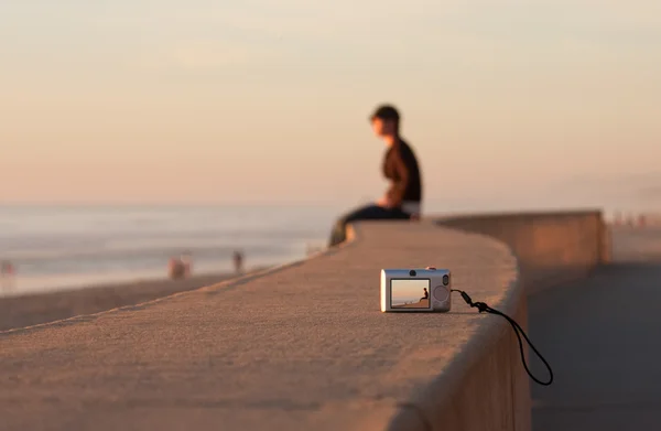 Человек на пляже Сансет сидит в одиночестве Стоковая Картинка