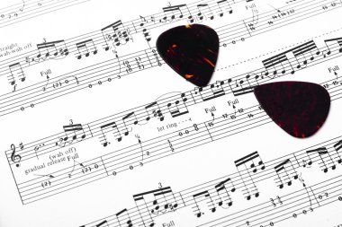 Guitar music sheet with pick clipart