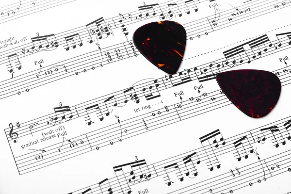 Guitar music sheet with pick — Stock Photo, Image