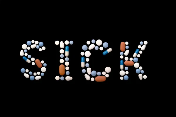 Palavra doente escrito com pílulas — Fotografia de Stock