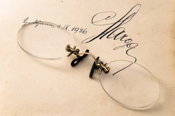 Óculos muito antigos em livro aberto — Fotografia de Stock
