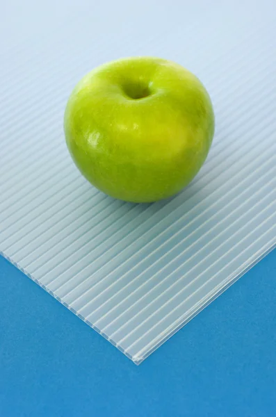 Зеленое яблоко на голубом — стоковое фото
