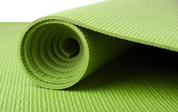 Зеленый коврик для йоги — стоковое фото