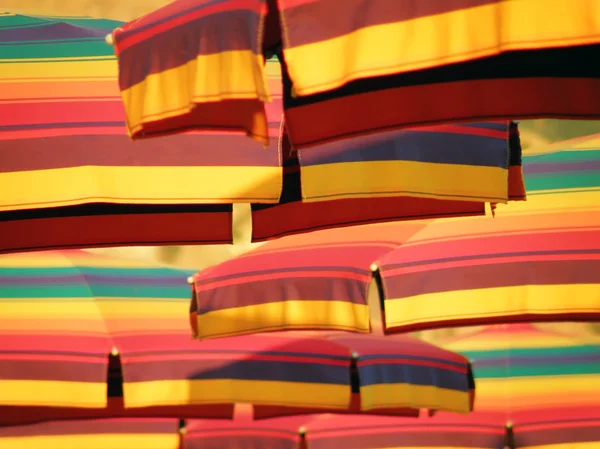 Enjoying under colorful sun umbrella — Stock Photo, Image