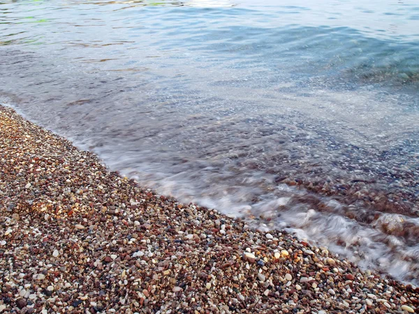 Movimiento borrosa ola en la playa de guijarros — Foto de Stock
