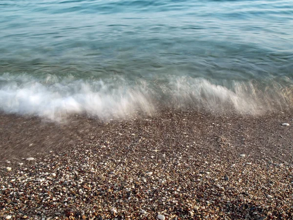 Waves on pebble beach — Stock Photo, Image