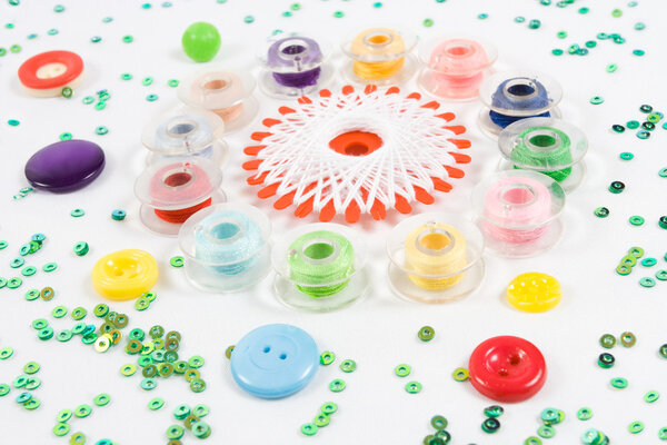 Sewqing bobbins, buttons, beads on white
