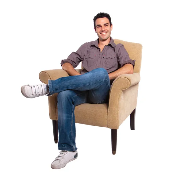 Junger Mann sitzt auf einem Sofa — Stockfoto