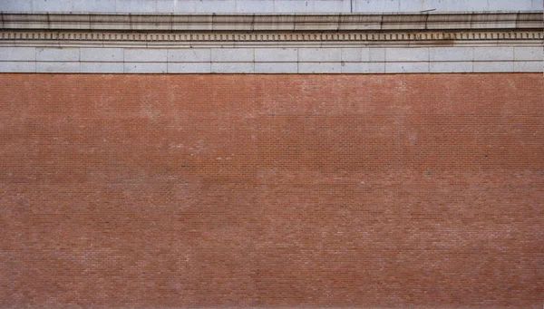 Кирпичная стена с каменным карнизом — стоковое фото