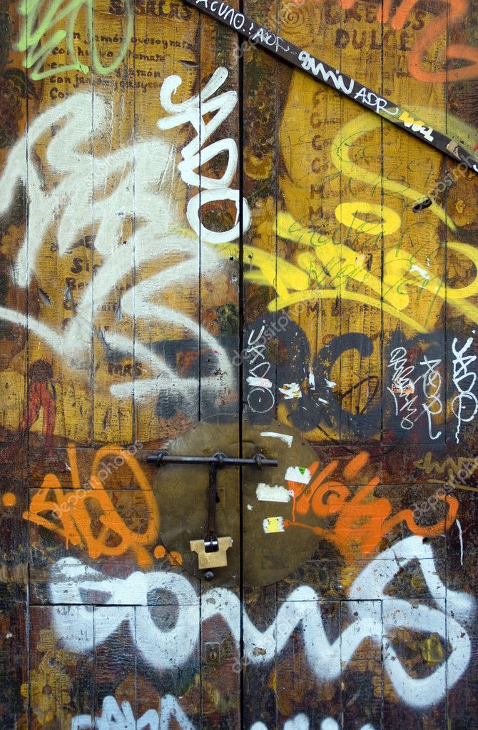 Old wooden door covered in graffiti — Stock Photo © franckito #2421404