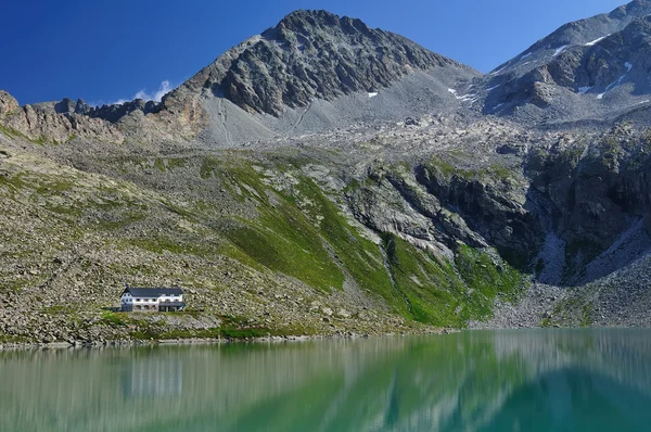 Alpské jezero a horské boudy — Stock fotografie