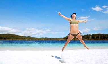 Female jumping on beach clipart