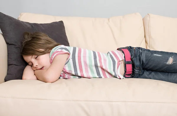 Criança dormindo em um sofá de couro — Fotografia de Stock