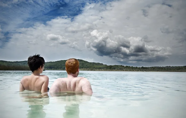 Νεαρό ζευγάρι χαλαρωτικό στη λίμνη Royalty Free Εικόνες Αρχείου