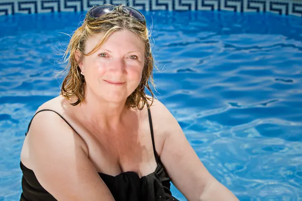Senior Lady Sentado à beira da piscina — Fotografia de Stock