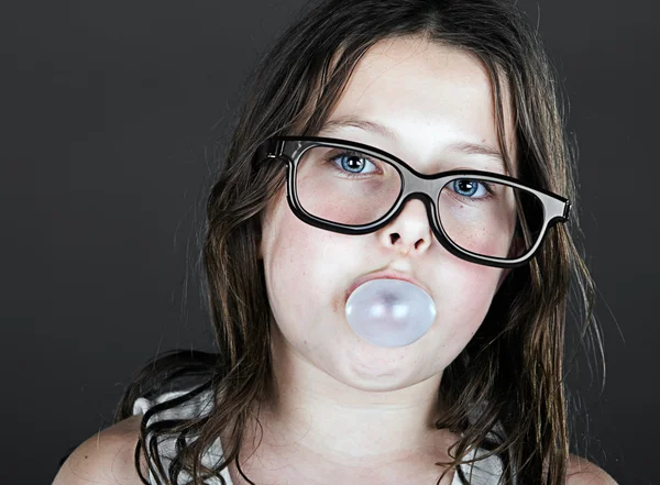 Bonito criança nerd soprando bolha — Fotografia de Stock