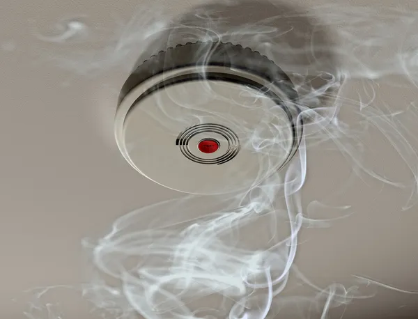 Пожарная сигнализация в комнате с дымом — стоковое фото