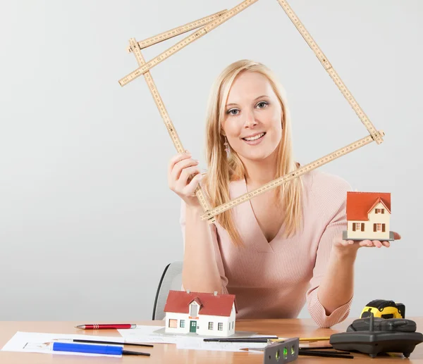 Arquitecta mujer sosteniendo exposición casa — Foto de Stock