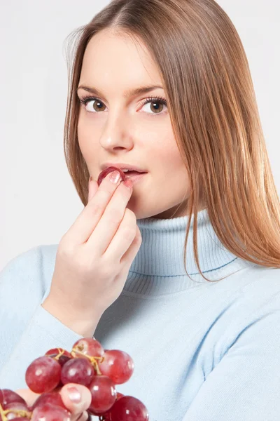 Woman eating red grapes — Stock Photo, Image