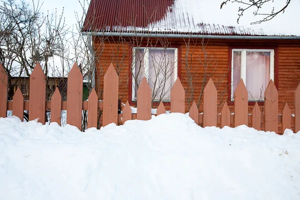 Dřevěný plot a dům v zimě — Stock fotografie