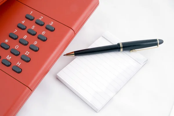Telefono rosso con notebook — Foto Stock