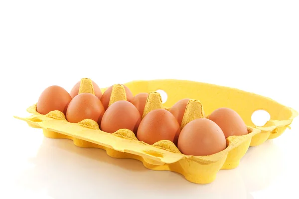 Hnědá vejce v žluté krabičce — Stock fotografie