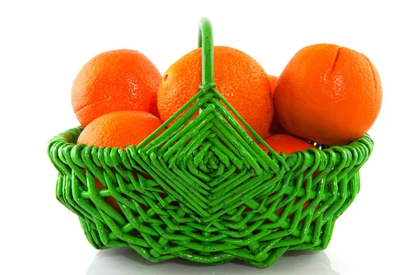 Orangen im grünen Korb — Stockfoto